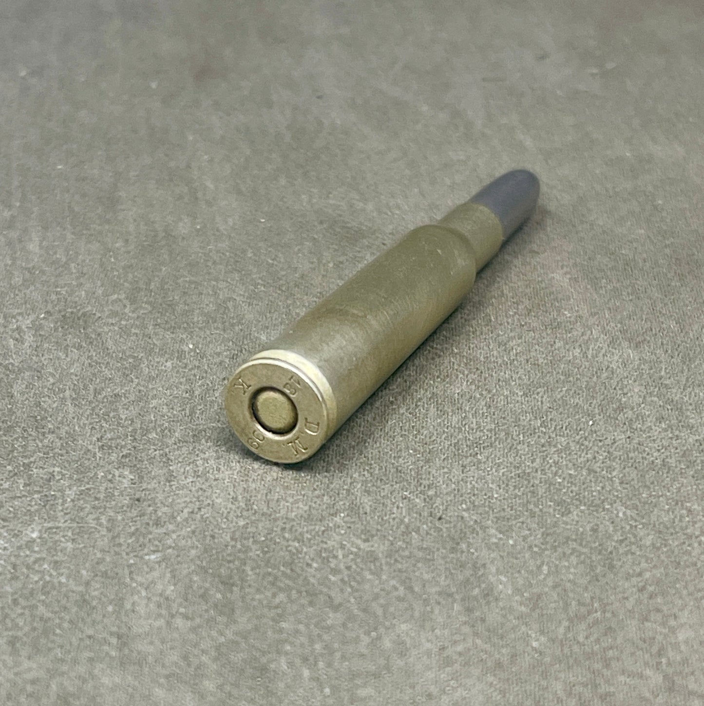 Metallic cylindrical object on a gray surface