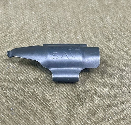 Metallic gun part with 'SAV' branding on a beige background