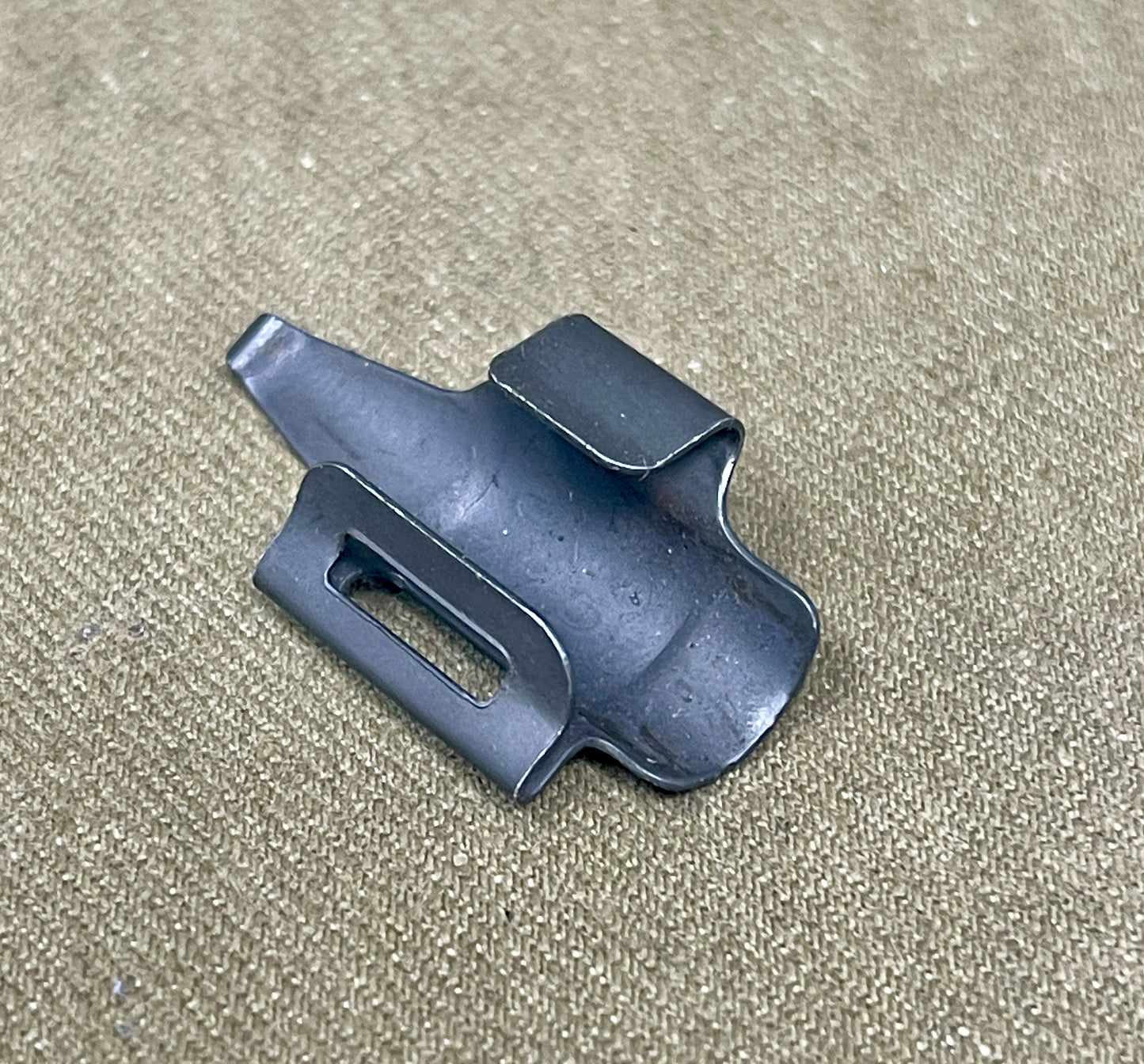 Black plastic clip on a beige textured background