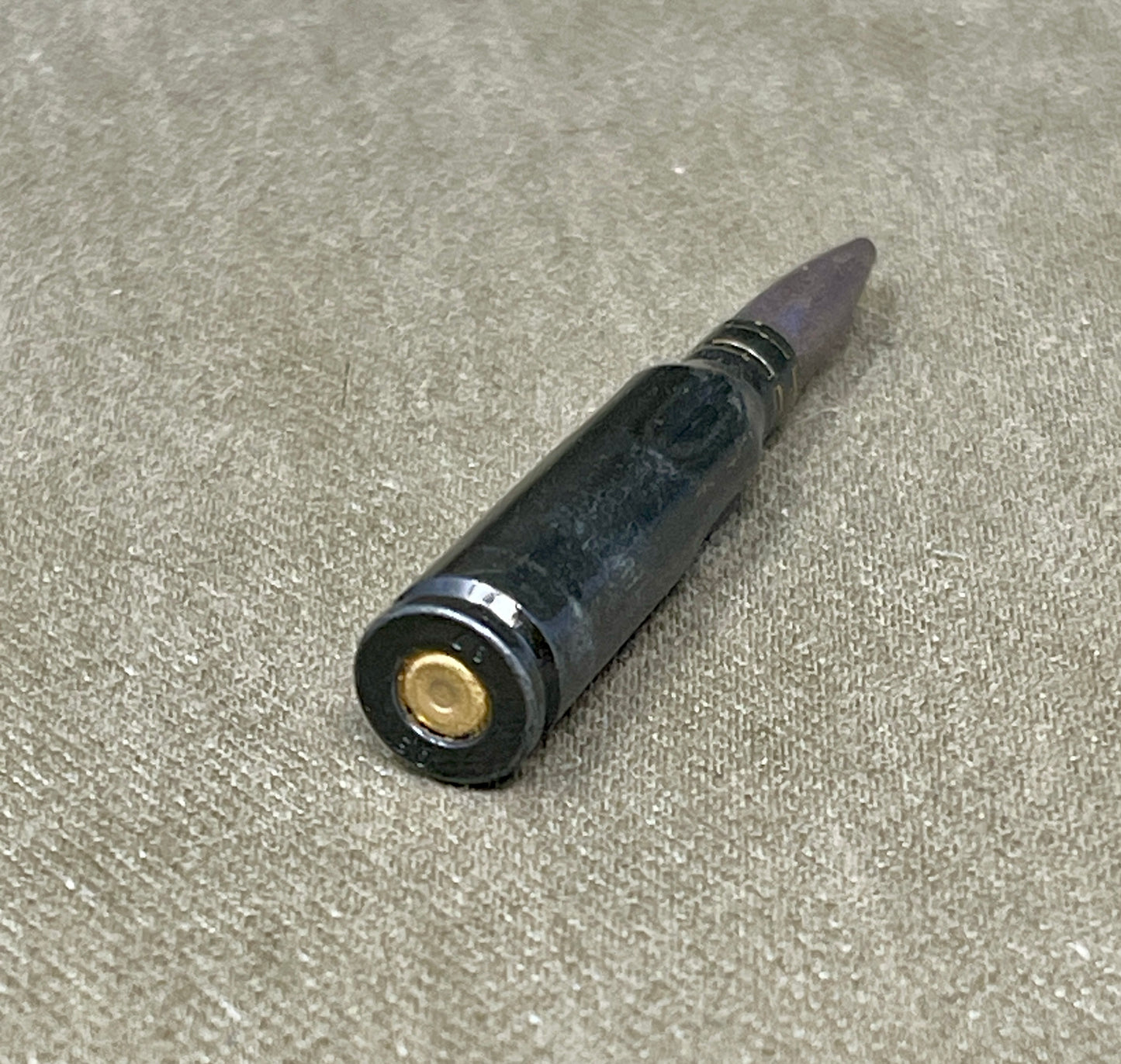 Black pen with gold clip on a gray surface