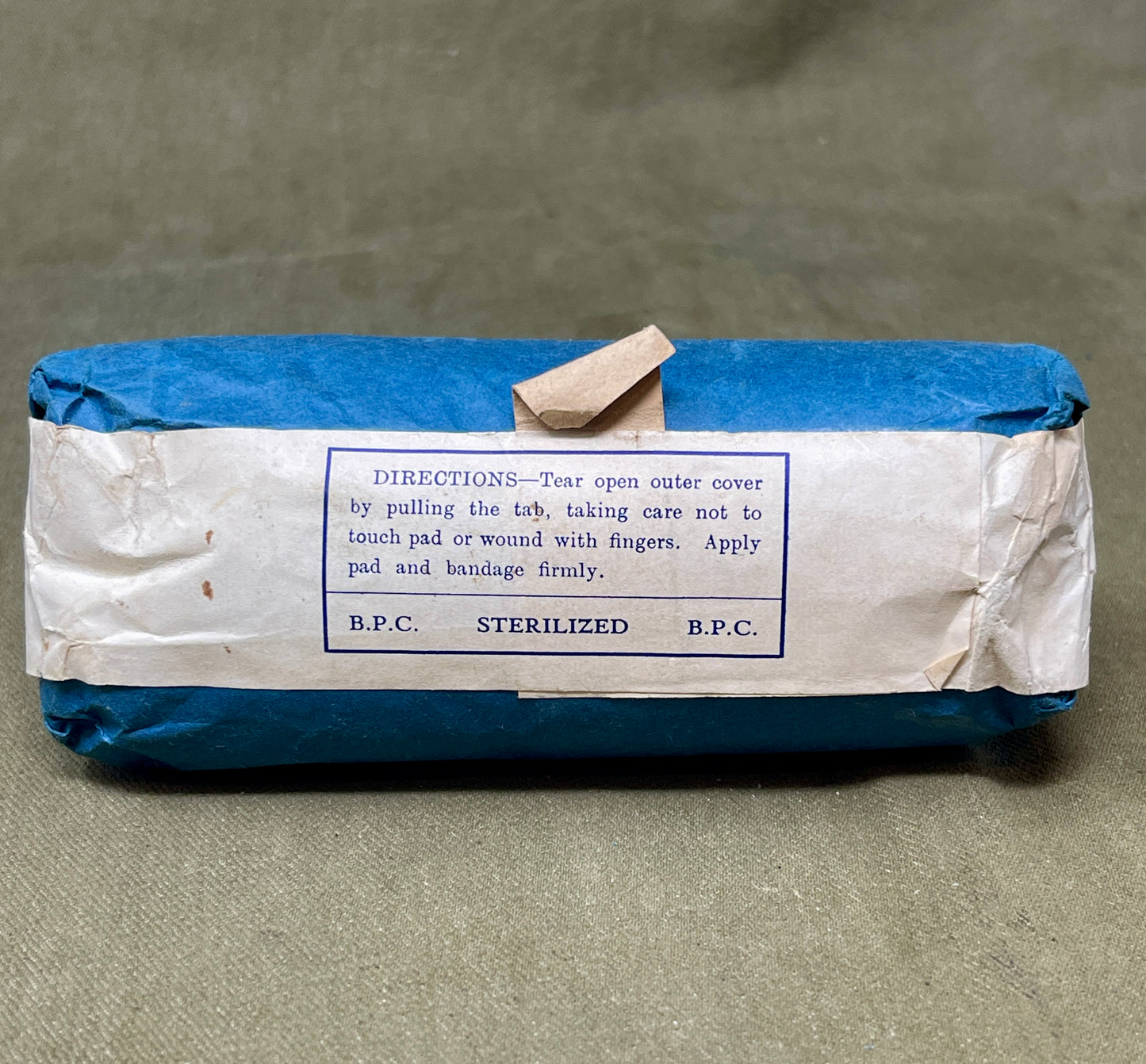 This Large First Aid Dressing, manufactured by T.J. Smith & Nephew Ltd in Hull, England, is a vintage medical supply that highlights the craftsmanship and practical design of mid-20th-century healthcare essentials. Known for its reliability and quality, Smith & Nephew was a renowned manufacturer of medical and surgical products, and this dressing reflects their commitment to excellence.
The dressing is designed for emergency use, providing a sterile and absorbent solution for treating wounds, cuts, or inju