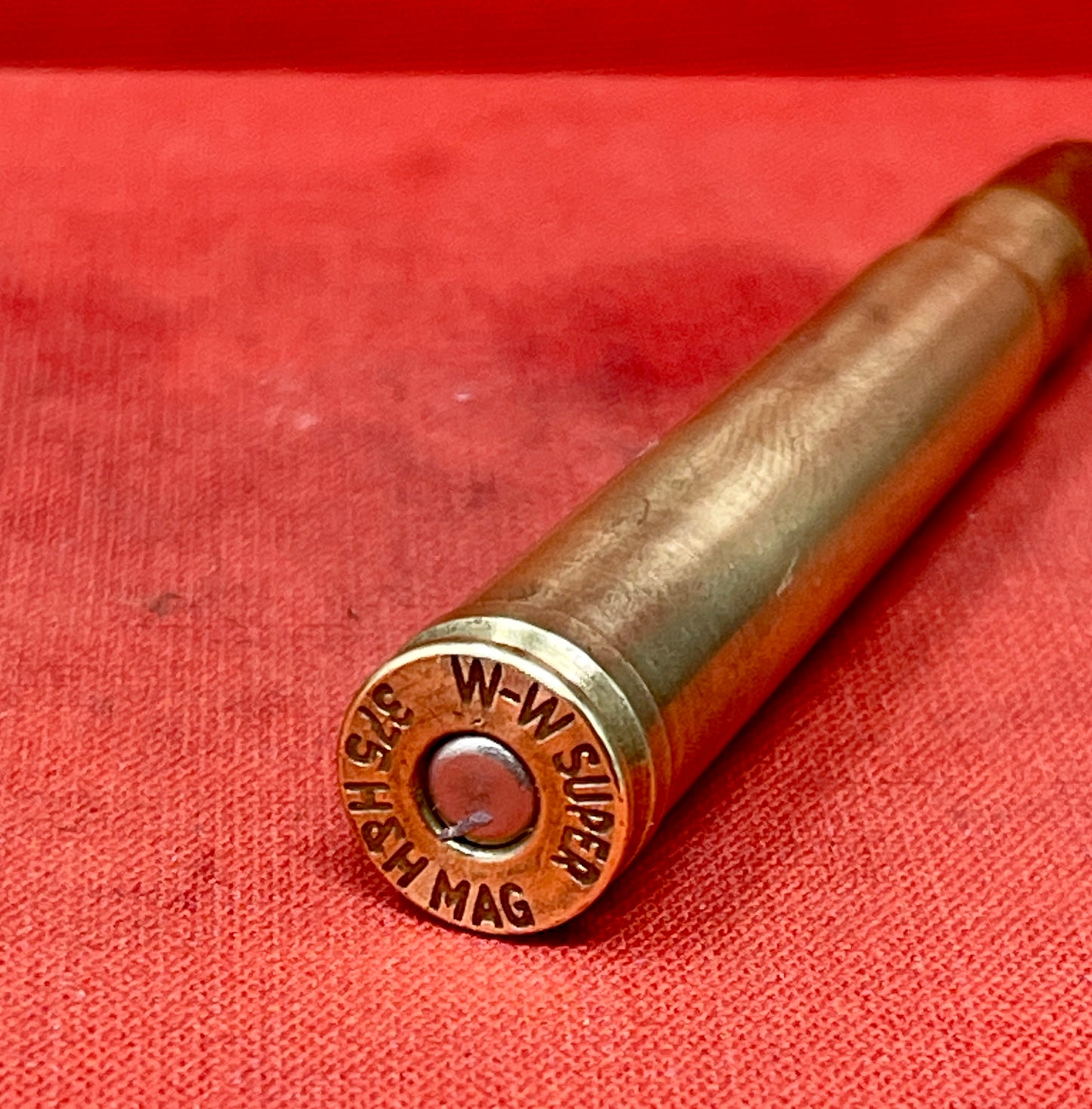 "Explore the INERT H&H .375 Magnum W-W Super Cartridge, a deactivated collectible showcasing big game hunting history and exceptional craftsmanship."
