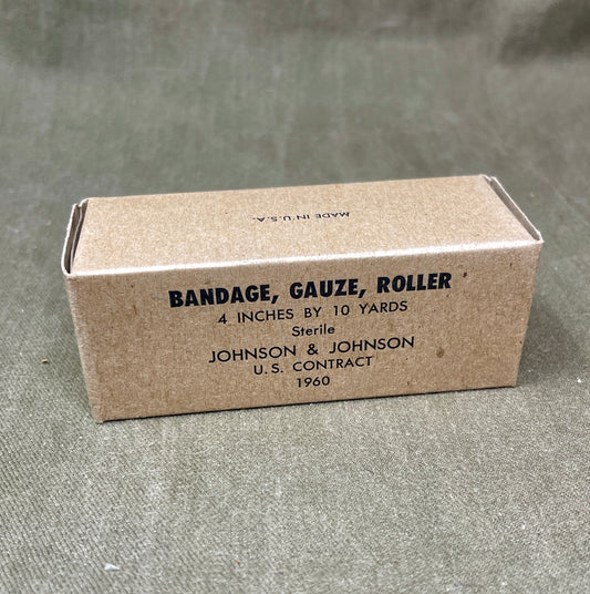 The U.S. Army Bandage, Gauze, Roller, 4 Inch by 10 Yards, Sterile was a military-issue medical supply used for wound dressing and stabilization. Manufactured by Johnson & Johnson under a U.S. government contract in 1960, this sterile gauze bandage was essential for treating injuries in field conditions.
Measuring 4 inches wide and 10 yards long, the bandage was designed for versatility in wound management, allowing medics and soldiers to wrap and secure dressings, control bleeding, and protect wounds from