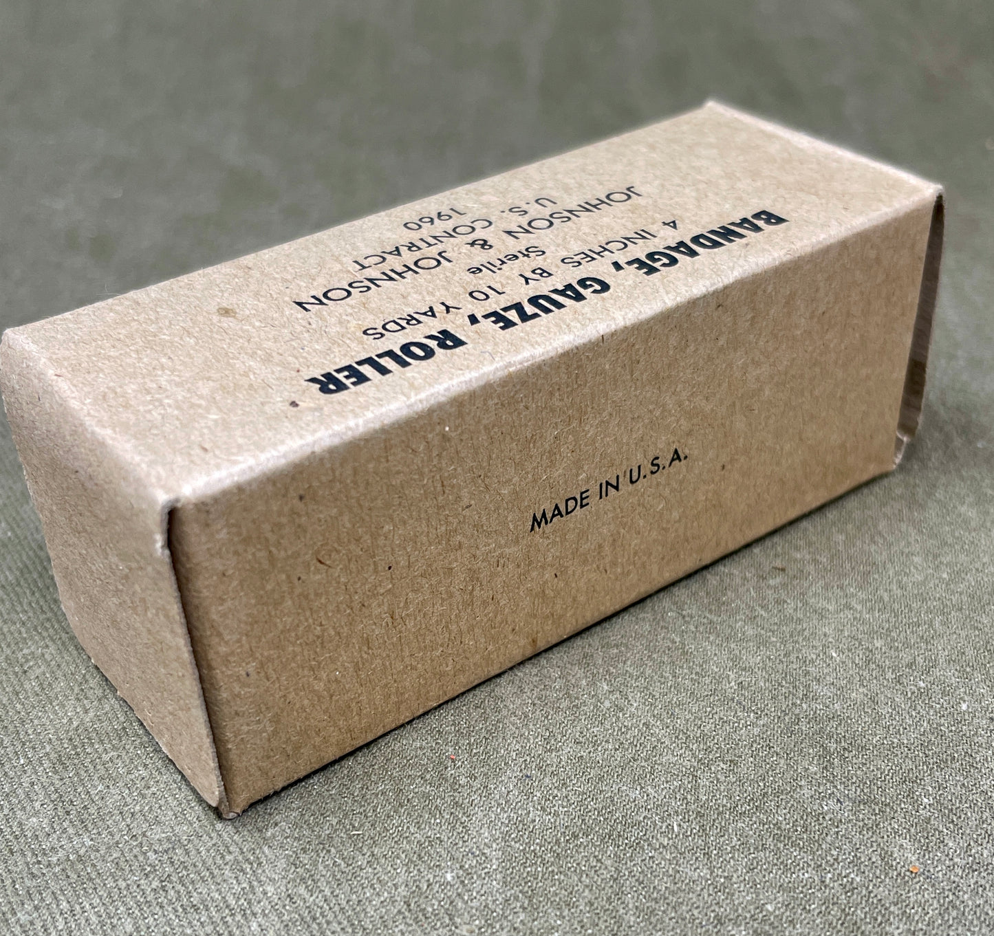 The U.S. Army Bandage, Gauze, Roller, 4 Inch by 10 Yards, Sterile was a military-issue medical supply used for wound dressing and stabilization. Manufactured by Johnson & Johnson under a U.S. government contract in 1960, this sterile gauze bandage was essential for treating injuries in field conditions.
Measuring 4 inches wide and 10 yards long, the bandage was designed for versatility in wound management, allowing medics and soldiers to wrap and secure dressings, control bleeding, and protect wounds from