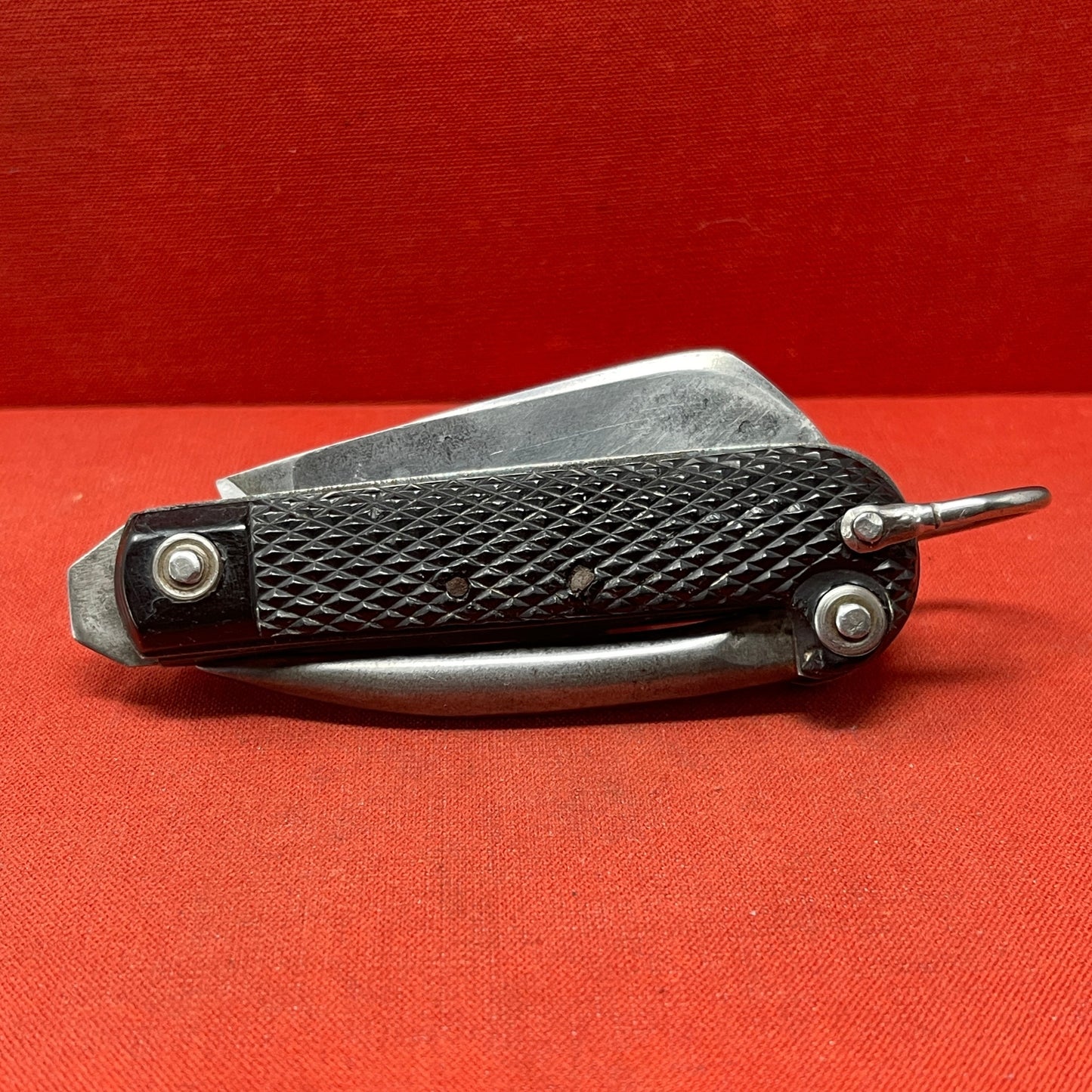 A nice example of a British 1944 Dated G Ibberson & Co military Jack Knife The blades are in good condition, the chequered Bakelite grip is intact and all the blades lock and close as they should. The steel can opener is in good condition