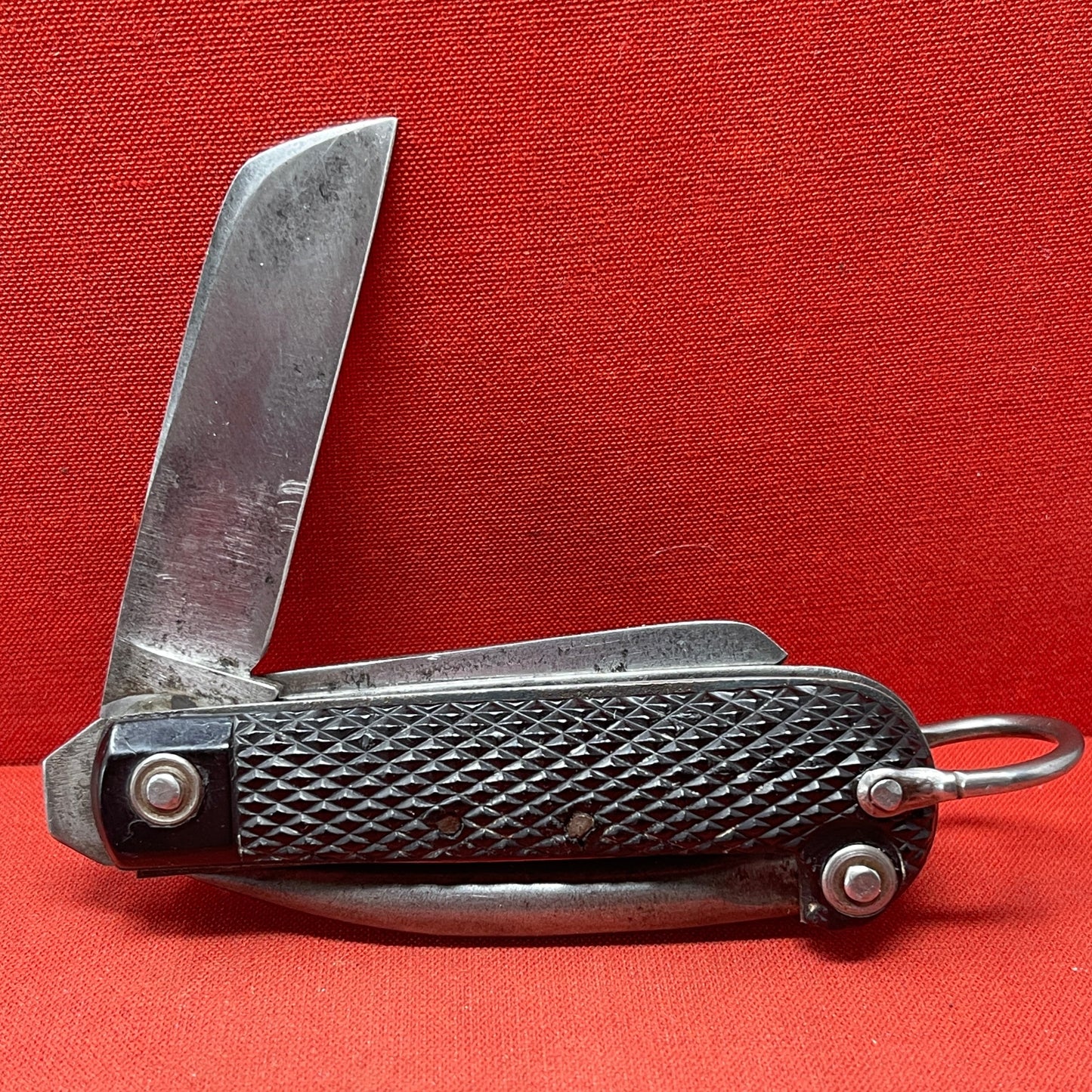 A nice example of a British 1944 Dated G Ibberson & Co military Jack Knife The blades are in good condition, the chequered Bakelite grip is intact and all the blades lock and close as they should. The steel can opener is in good condition