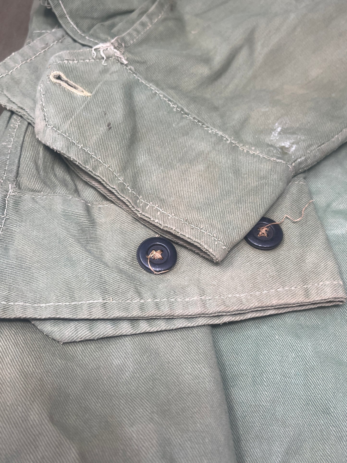 This original 1951-dated British Army Jungle Green Bush Jacket is a superb example of early post-war tropical combat clothing, manufactured by the reputable N. Lotery & Co. Ltd. Made from sturdy, breathable cotton in classic Jungle Green, this jacket was designed for use in humid and challenging environments such as Malaya and other post-war theatres of operation.
The jacket is in excellent condition, showing minimal signs of wear, with its color, stitching, and structural integrity all remarkably well-pre