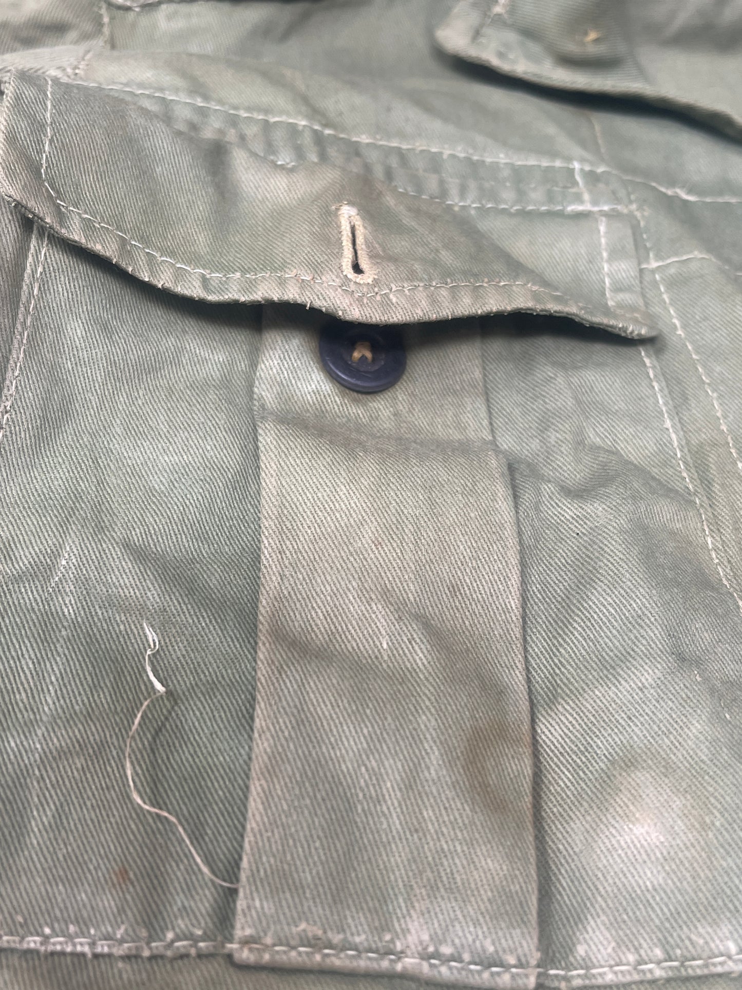 This original 1951-dated British Army Jungle Green Bush Jacket is a superb example of early post-war tropical combat clothing, manufactured by the reputable N. Lotery & Co. Ltd. Made from sturdy, breathable cotton in classic Jungle Green, this jacket was designed for use in humid and challenging environments such as Malaya and other post-war theatres of operation.
The jacket is in excellent condition, showing minimal signs of wear, with its color, stitching, and structural integrity all remarkably well-pre