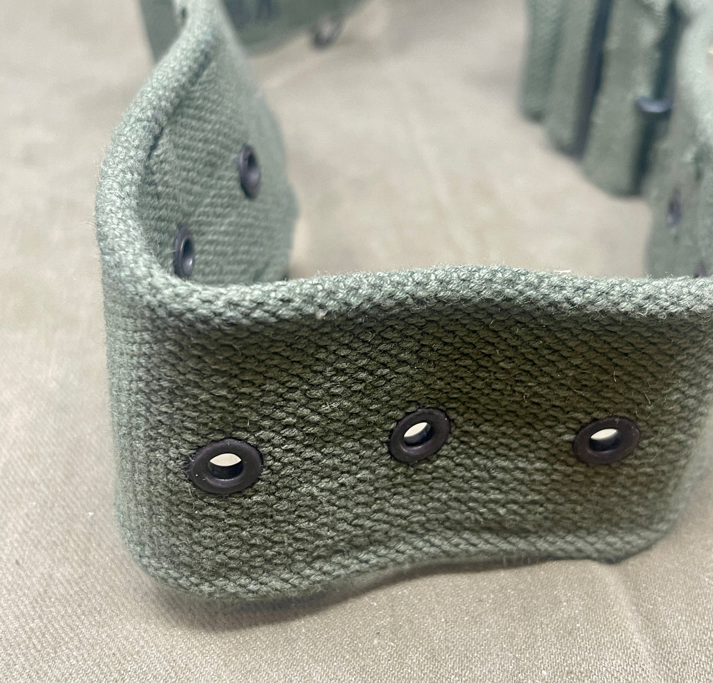 Green knitted headband with black buttons on a beige background