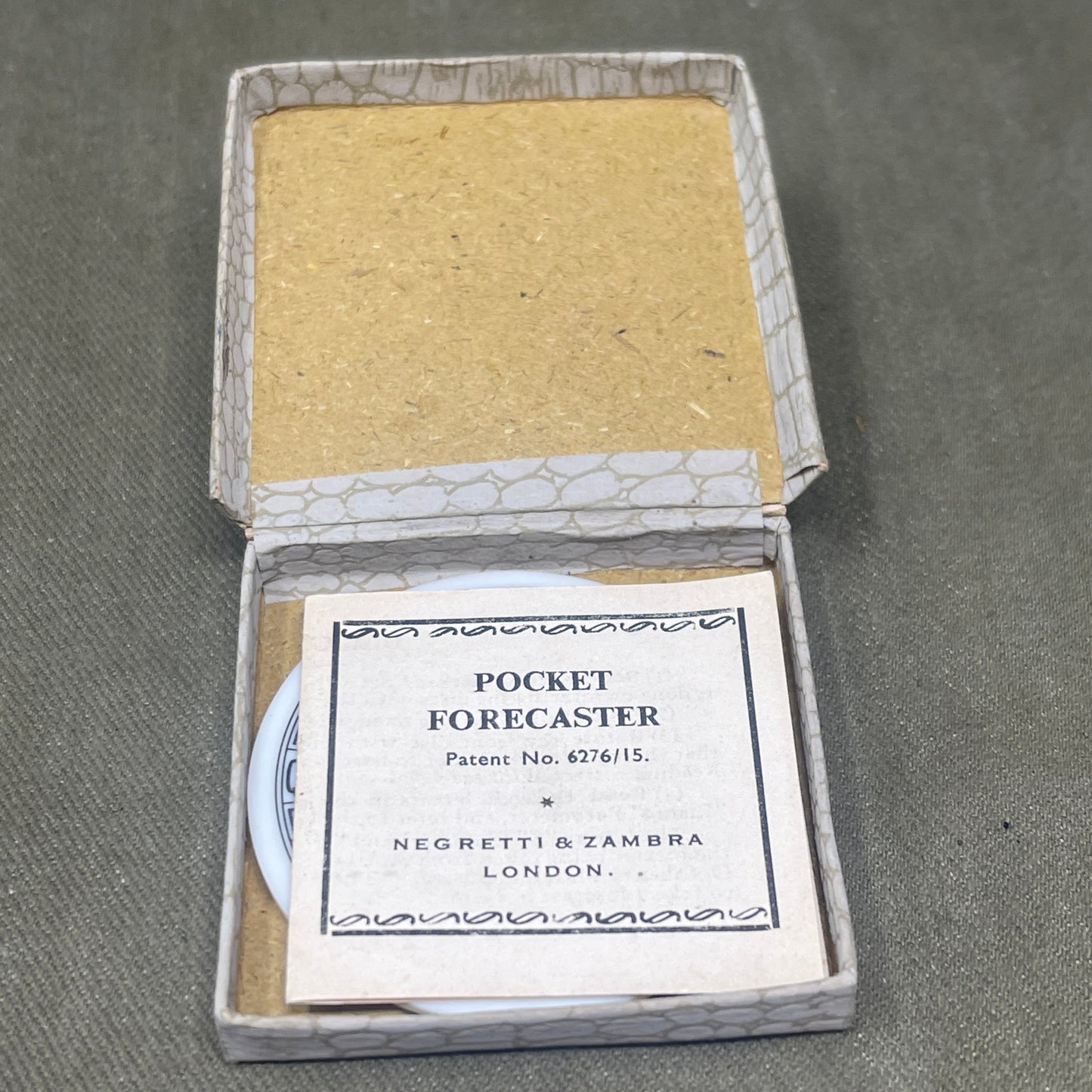 Small open box with a yellow square and a label on a gray background