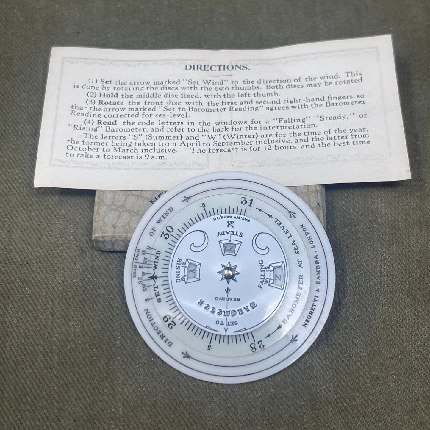 Circular device with text and symbols on a piece of paper against a textured background