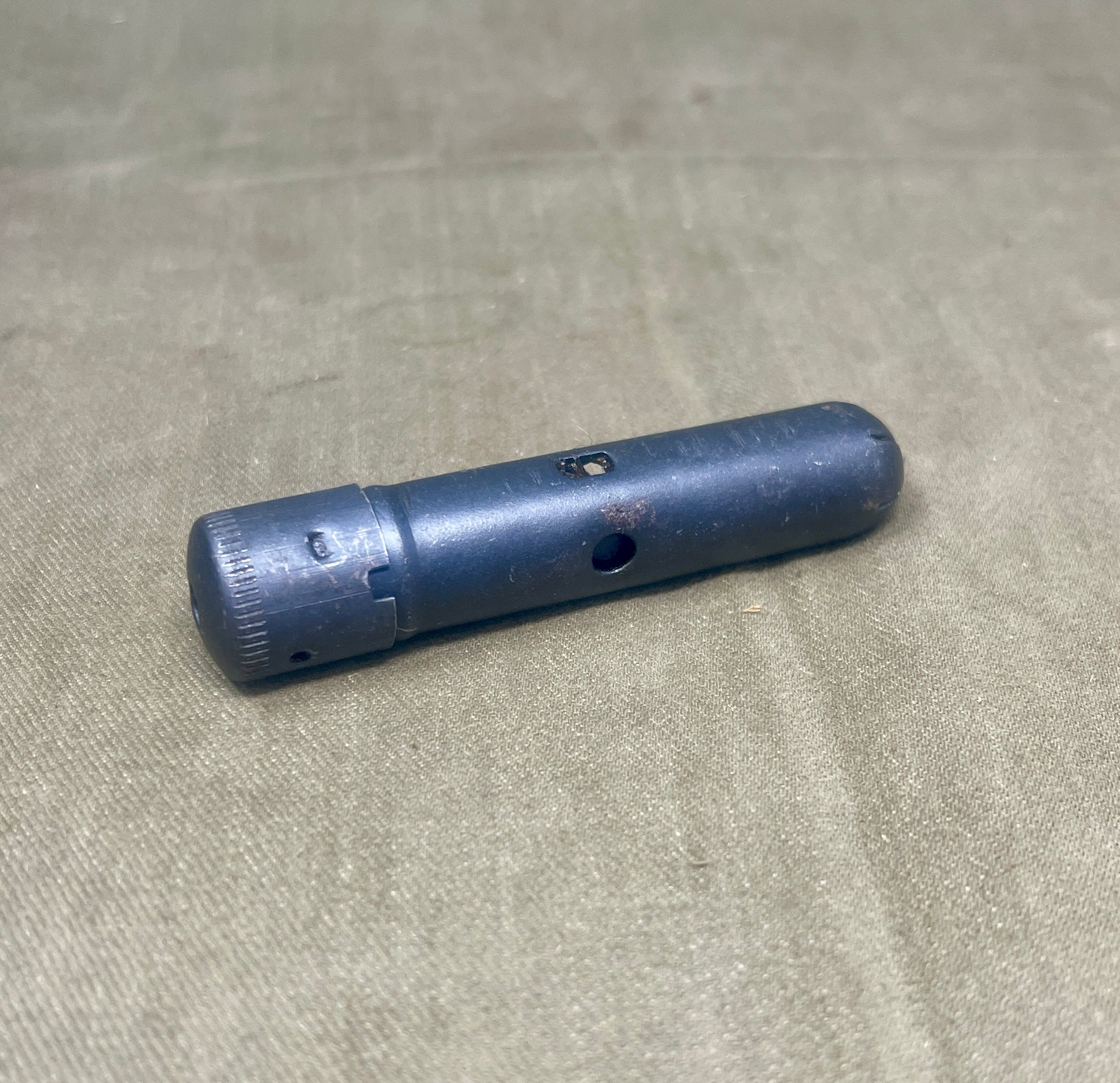 Blue cylindrical object on a beige fabric background