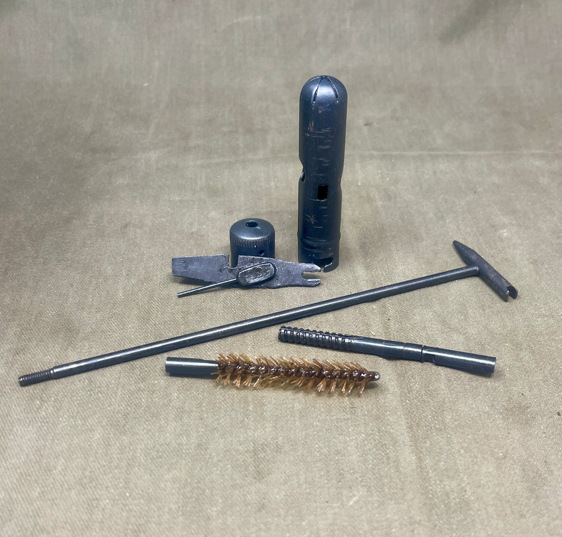 Set of gun cleaning tools on a beige fabric background