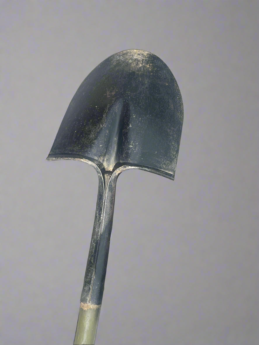 Black metal shovel on a stone pavement