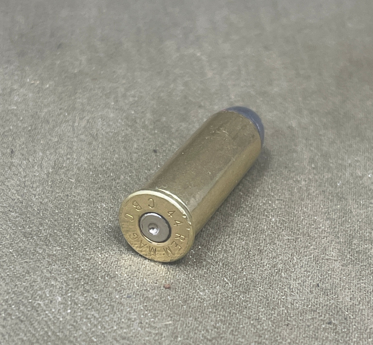 Metallic shotgun shell on a gray surface