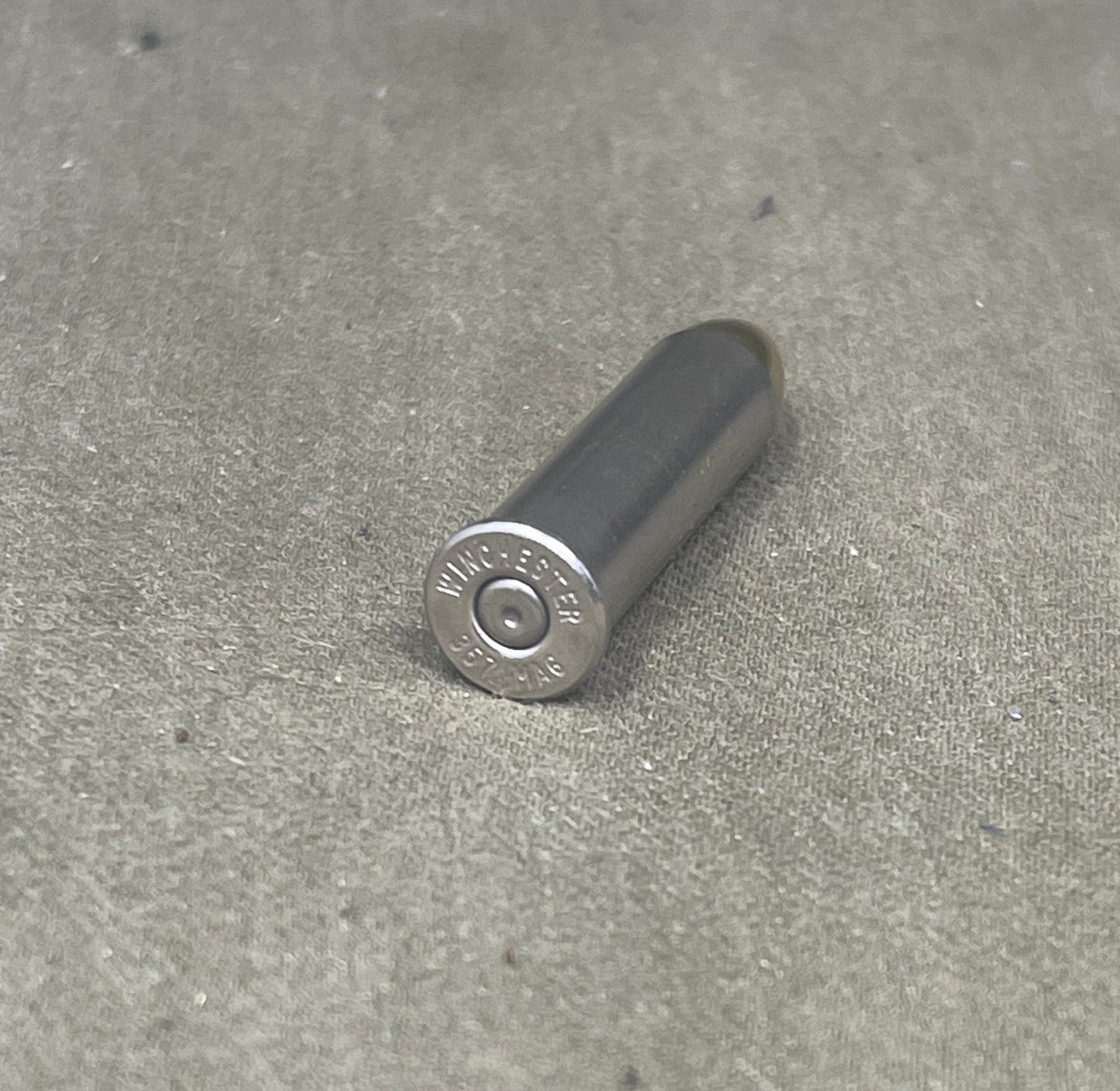 Metallic cylindrical object with 'Winchester' branding on a concrete surface