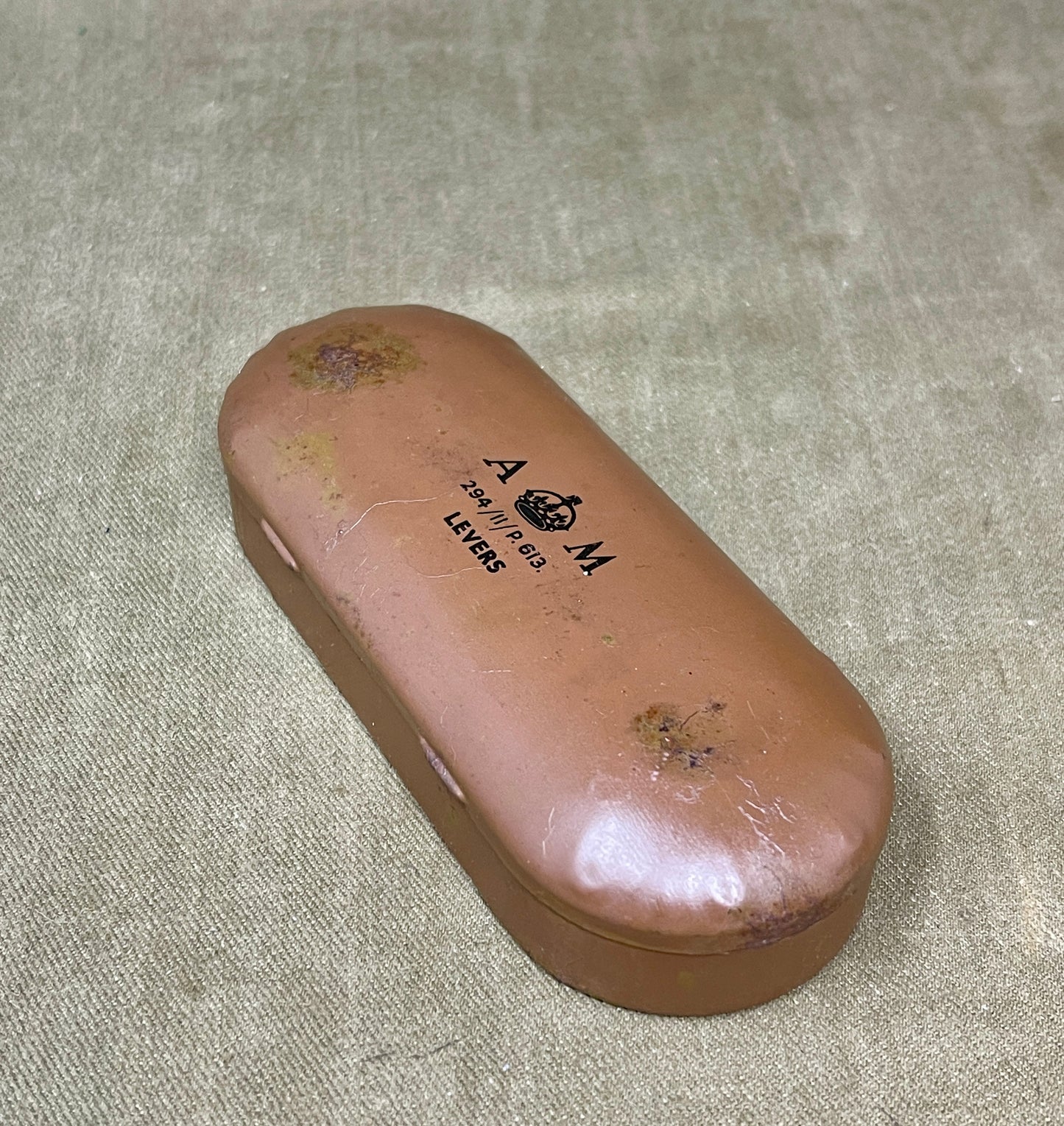 Brown eyeglass case with 'A.M.' branding on a textured surface