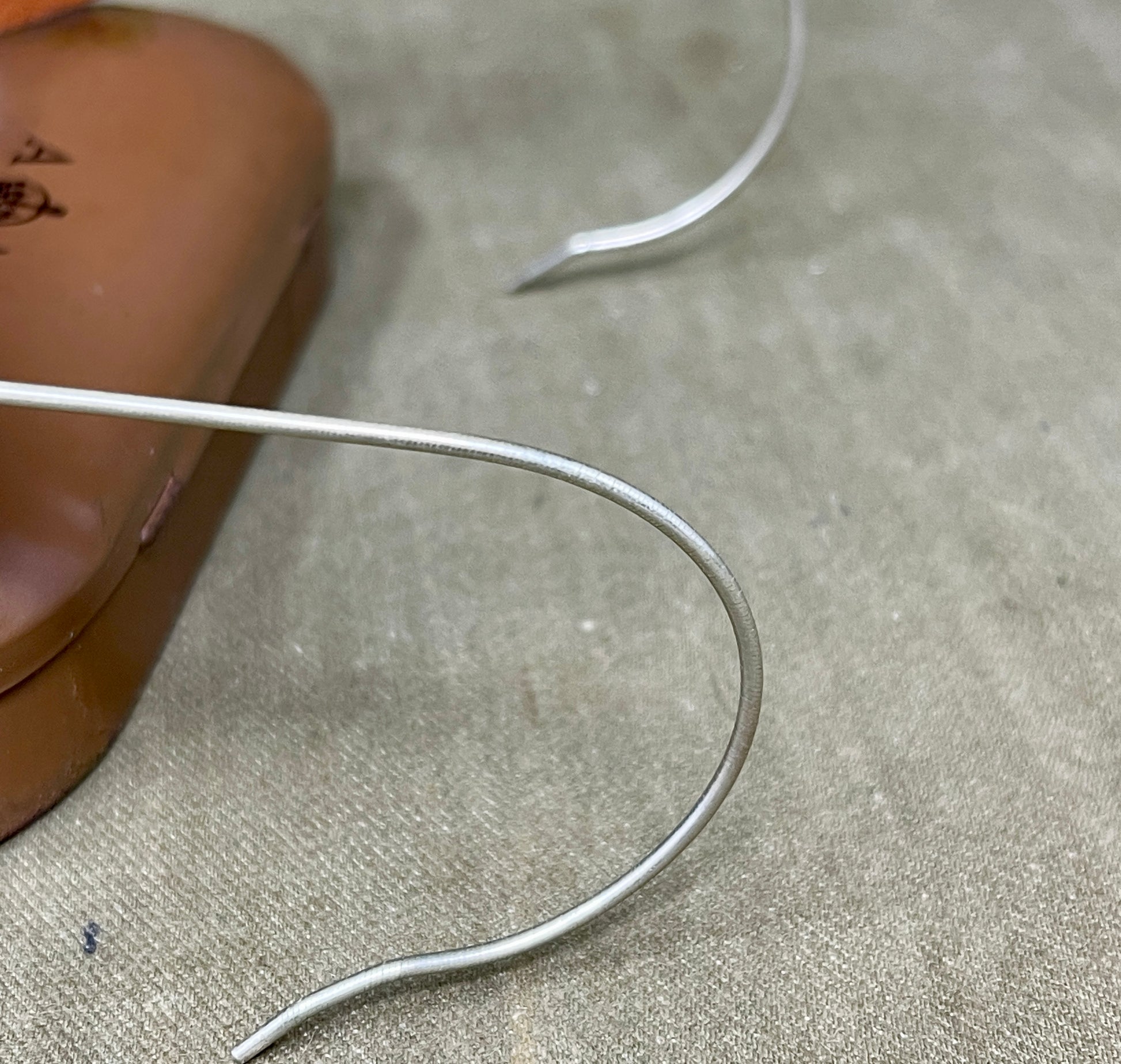 Close-up of a silver earring on a textured surface