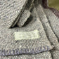 Close-up of a textured fabric with a label on a stone surface
