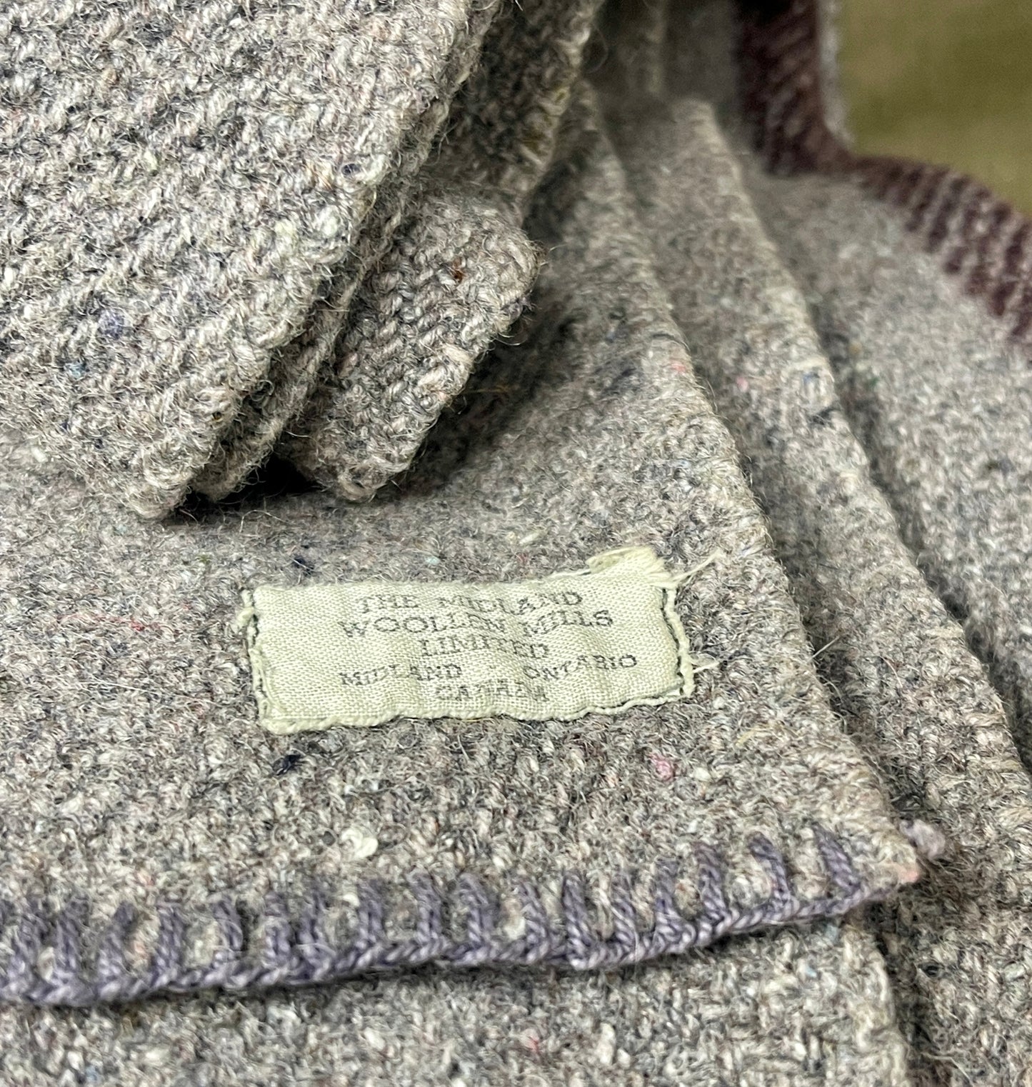 Close-up of a textured fabric with a label on a stone surface
