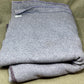 Folded gray garment on a beige surface