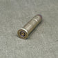 Metallic bullet casing on a textured gray surface
