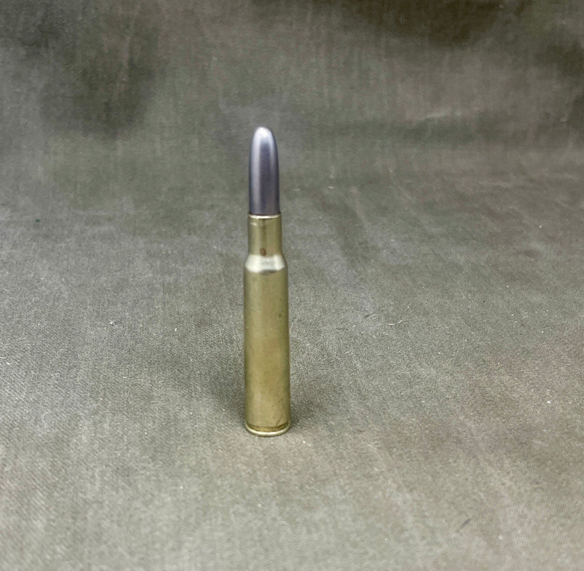 Barely visible bullet casing on a gray fabric background