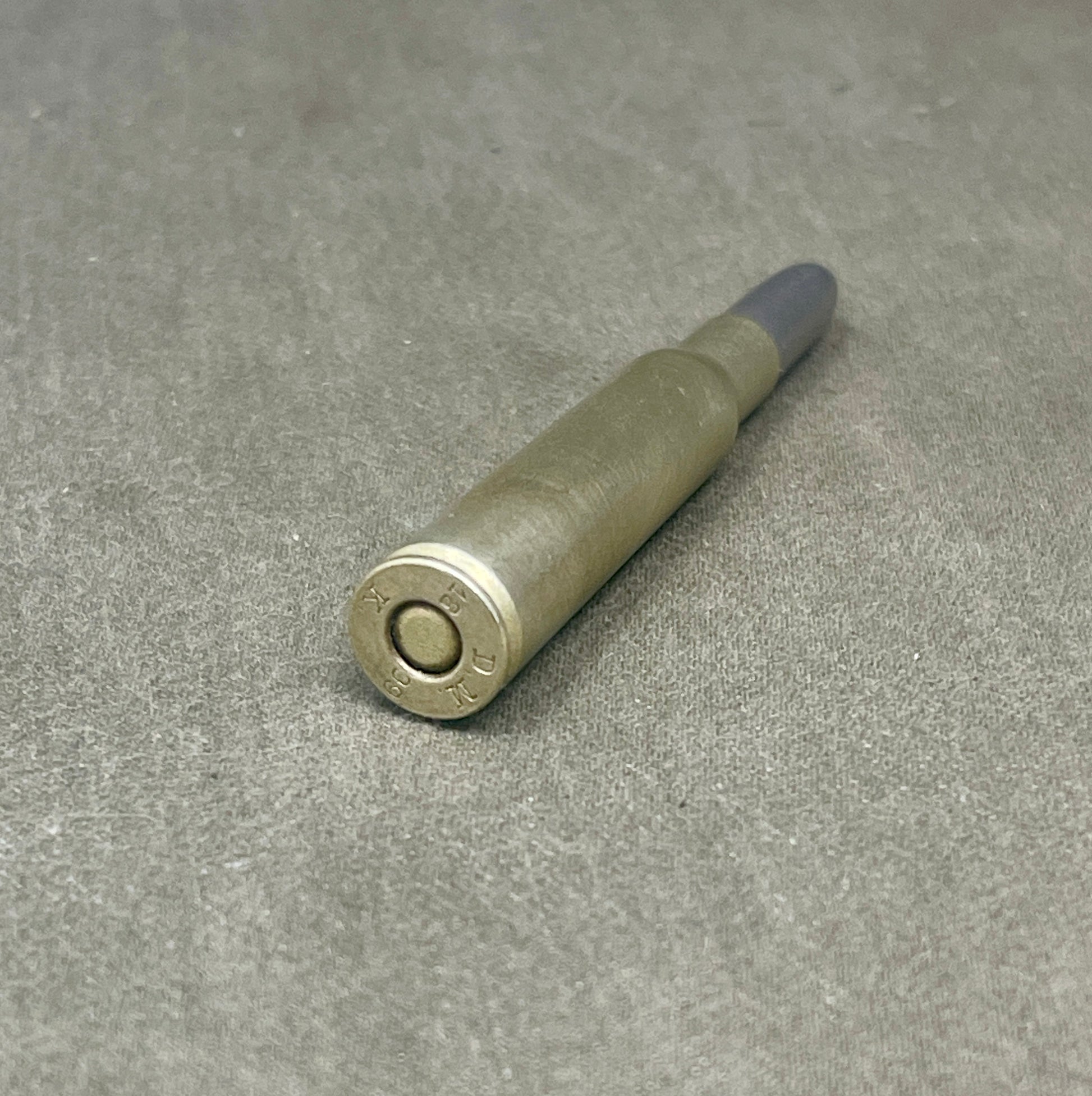 Metallic cylindrical object on a gray surface