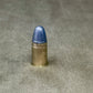 Bullet with blue tip on a gray concrete surface