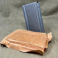 Brown paper bag with a blue metal object on a gray background