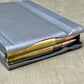 Gray ammunition magazine with gold-colored bullets on a concrete surface