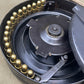 Close-up of a mechanical component with gears and a central shaft on a beige background