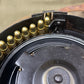 Close-up of a firearm magazine with bullets and a black metal casing.