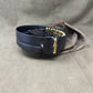 Black belt with gold buckle on a gray fabric background