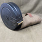 Black ammunition clip with a beige magazine pouch on a beige fabric background