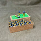 Cardboard box filled with small cylindrical objects on a gray surface