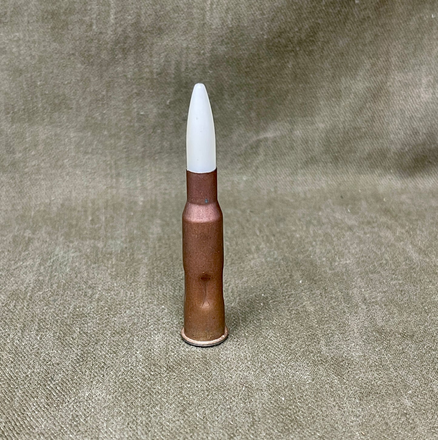 Bullet with a white tip on a textured gray background