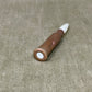 Wooden pen with white cap on a beige fabric background