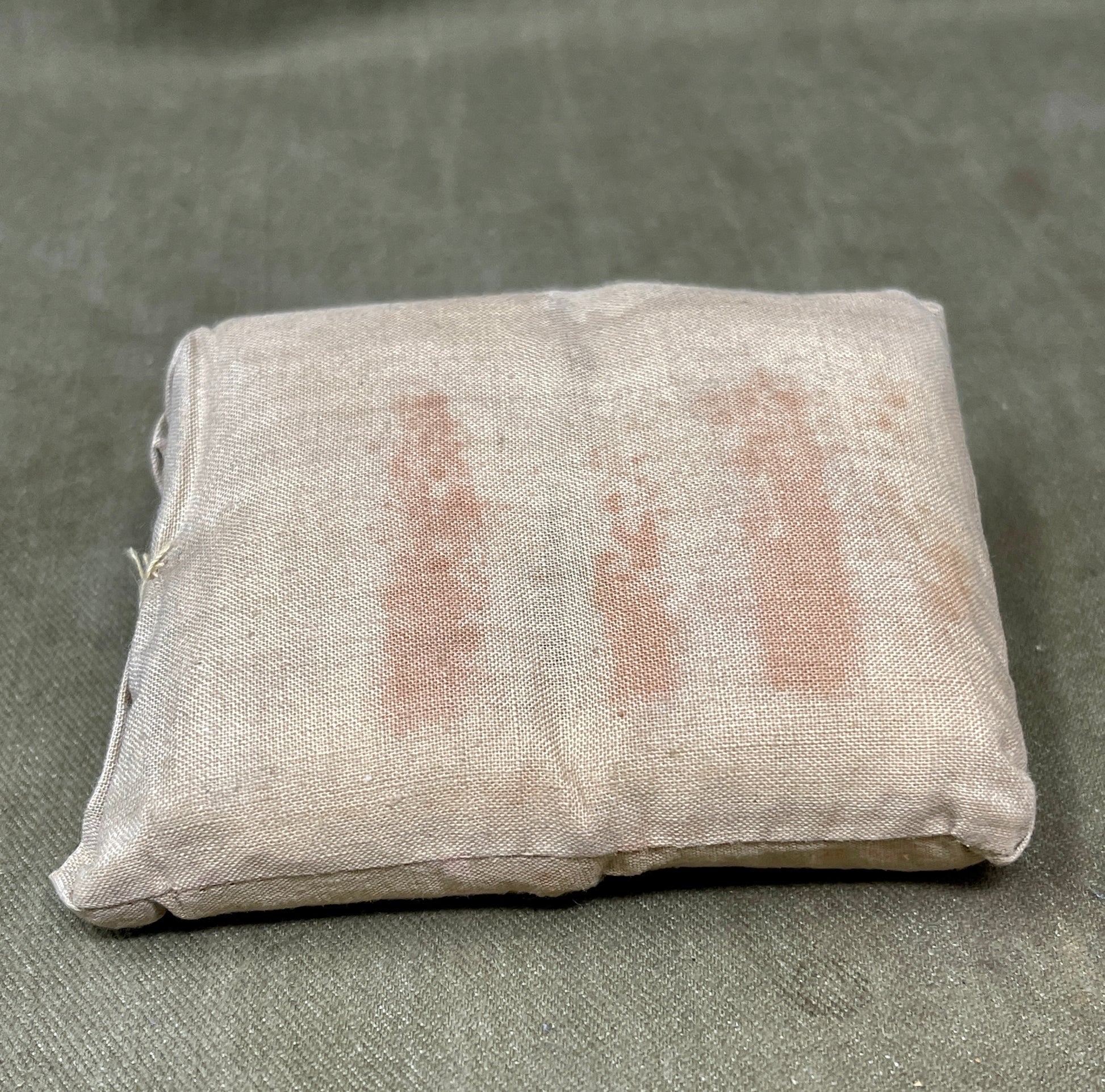 Fabric sample with red stains on a gray background