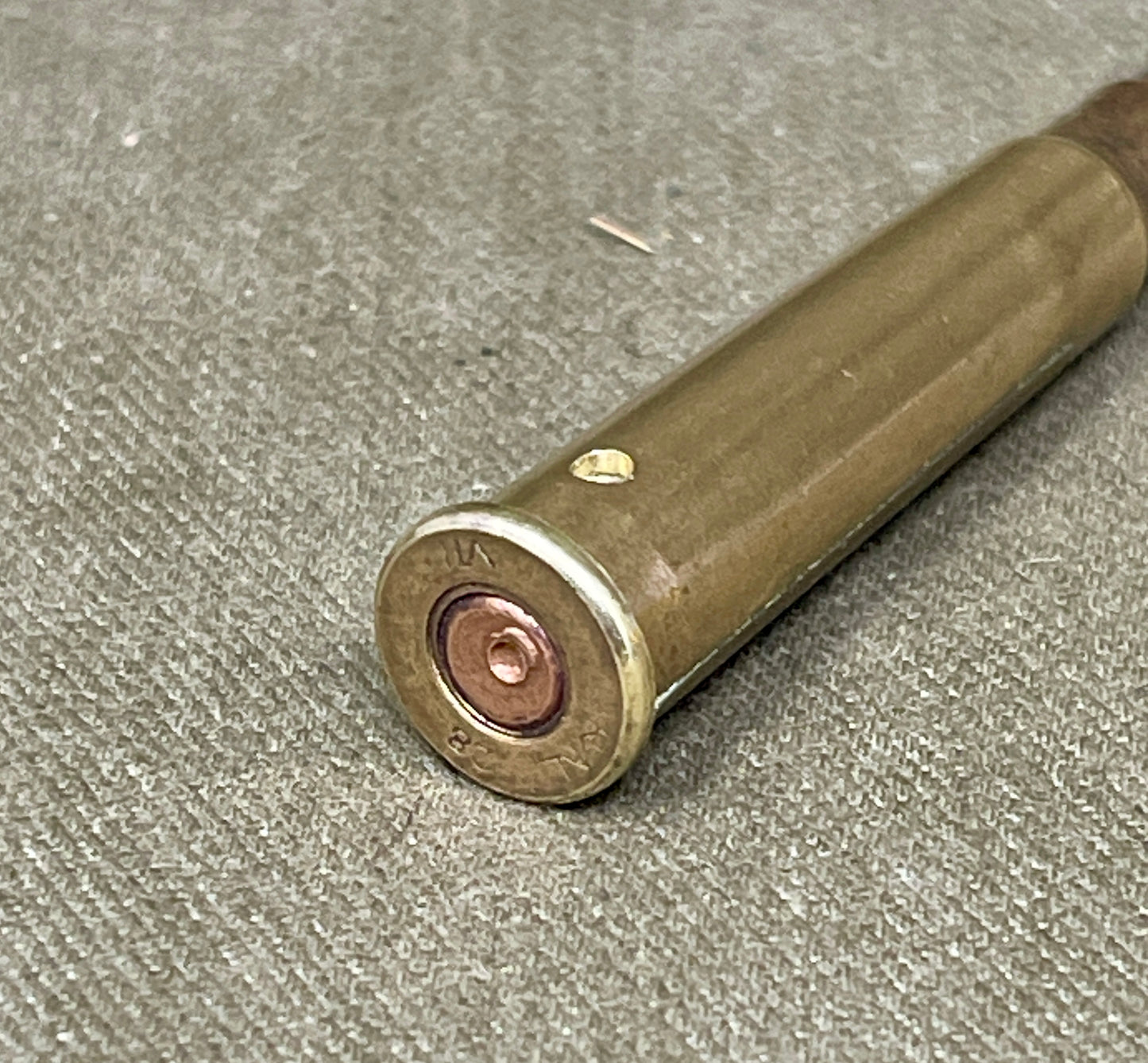 Close-up of a rifle cartridge on a textured surface