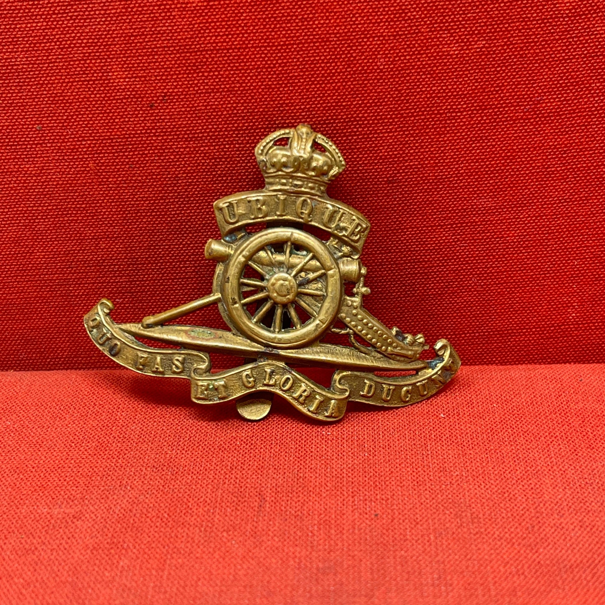 The Royal Artillery cap badge is a symbol of the regiment's distinguished history and service. Featuring a field gun at its center, the badge represents the regiment's core role in providing artillery support. Above the gun sits the British Crown, indicating loyalty to the monarchy. The badge often includes the Latin motto "UBIQUE" (meaning "Everywhere"), signifying the Royal Artillery's global presence, and "QUO FAS ET GLORIA DUCUNT" ("Where Right and Glory Lead"), reflecting its honorable service. This ic