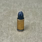 Bullet casing with a blue projectile on a textured surface
