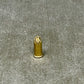 Small brass bullet-shaped object on a textured gray surface