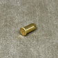 Brass cylindrical object on a textured gray surface
