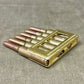 Metallic ammunition clip on a textured gray surface