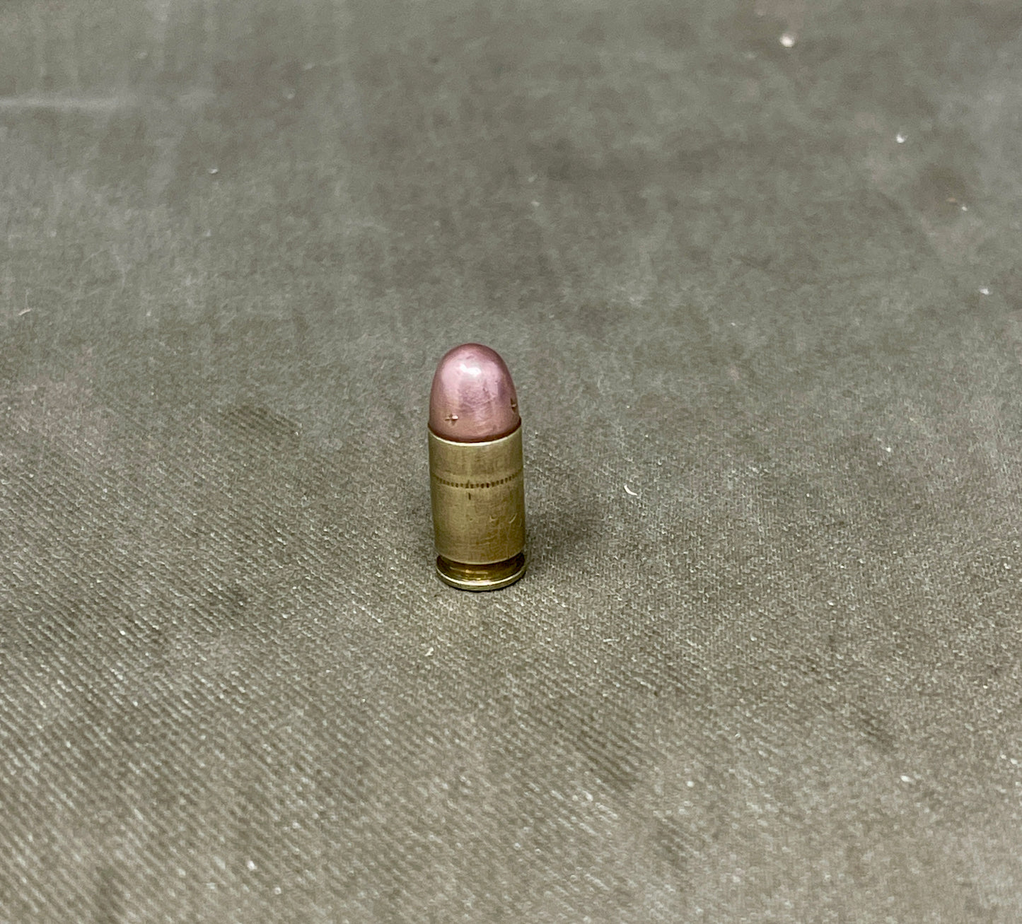 Single bullet on a textured gray surface