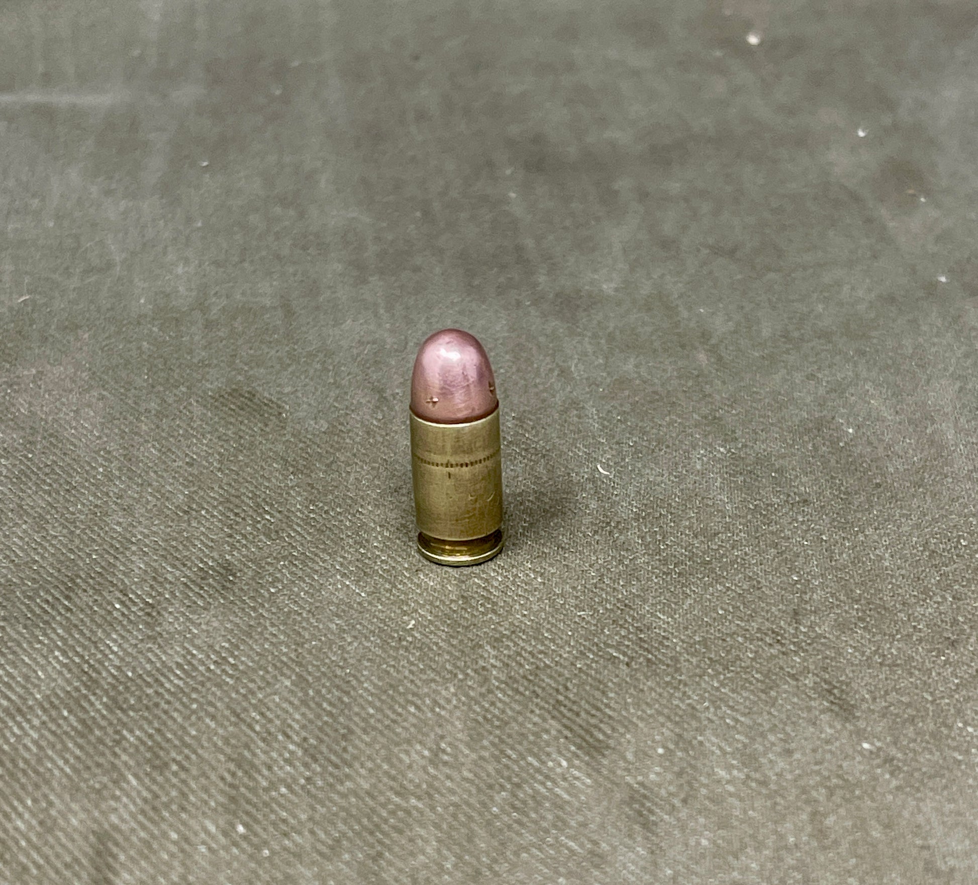 Single bullet on a textured gray surface