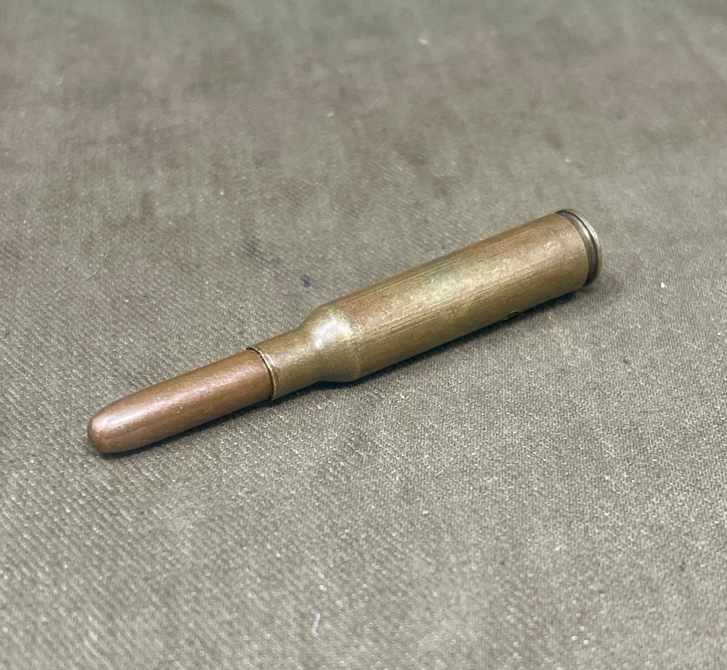 Metallic cylindrical object on a gray surface