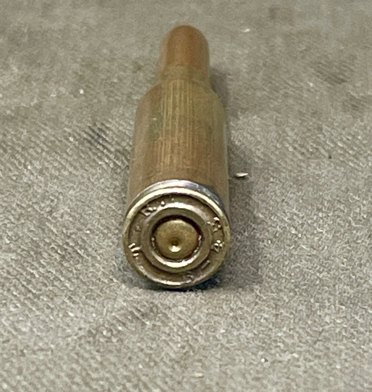 Bronze-colored cylindrical object on a textured gray surface