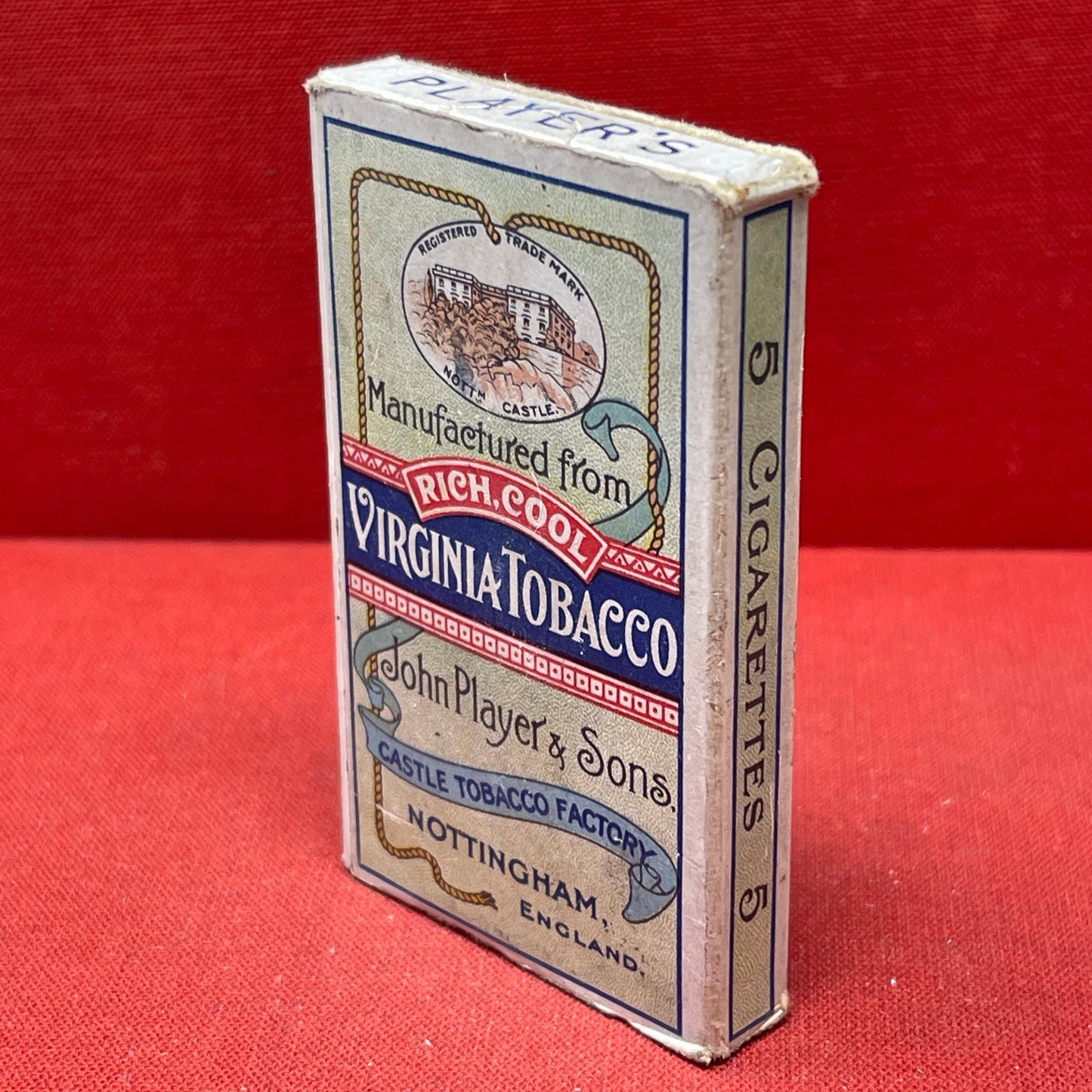 An empty packet for 10 Player's Medium Navy Cut cigarettes. The front has an ocean scene and a sailor framed in a life belt.